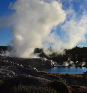 a geyser with steam coming out of it in a field