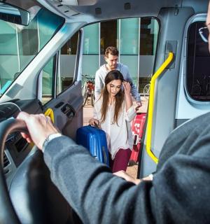 גבר נוהג באוטובוס עם אישה עם מזוודות
