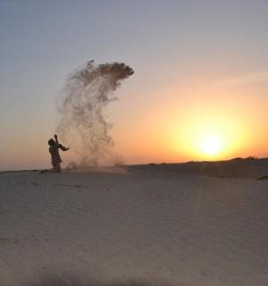 osoba stojící v písku v poušti