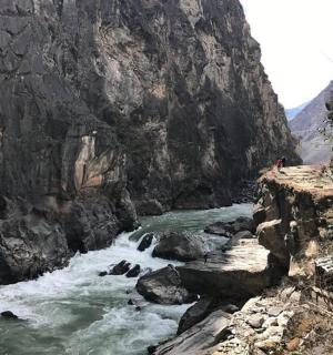 站在河边桥上的人