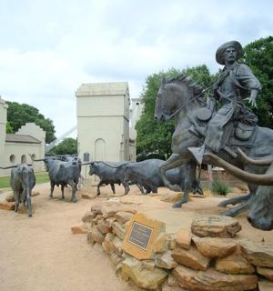 a statue of a man on a horse and cattle