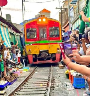 a crowd of people are taking pictures of a train