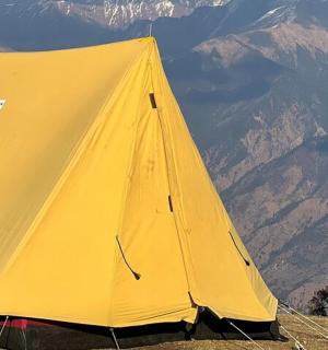 a yellow tent sitting on top of a mountain