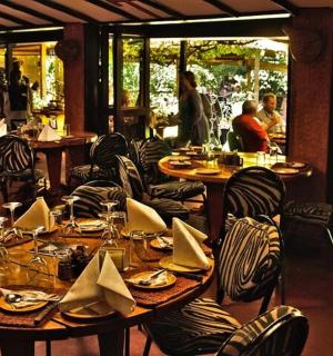 a restaurant with tables and chairs and people walking around