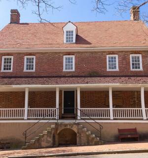 一栋带有白色门廊的旧红砖房子