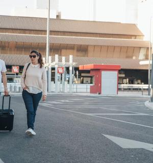 一男一女提着行李箱走在街上