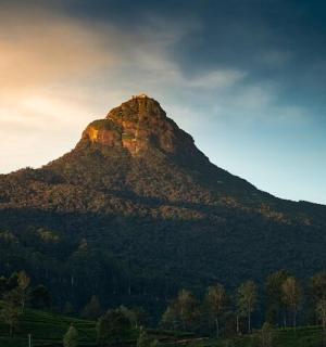 a mountain with the sun setting on top of it
