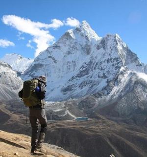 一个背着背包的男人站在山顶上