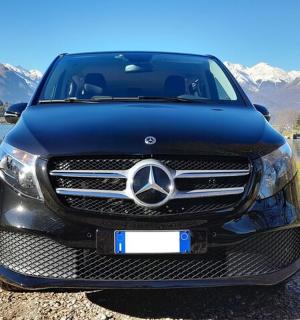 Černé auto Mercedes Benz zaparkované vedle jezera
