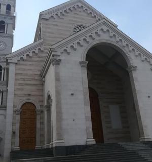 a large church with a clock tower and stairs