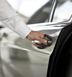 osoba otevírající dveře auta klíčem