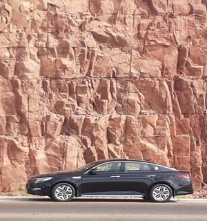 černé auto zaparkované před skalní zdí