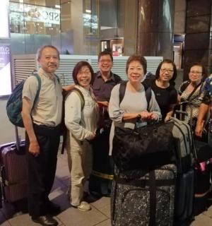 a group of people posing for a picture with their luggage