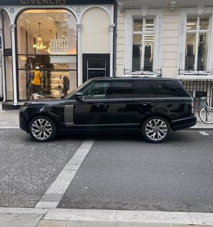 a black suv parked in front of a store
