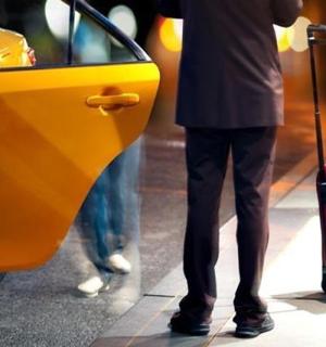 muž stojící vedle žlutého auta s kufrem