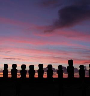 a group of silhouettes of people watching a sunset