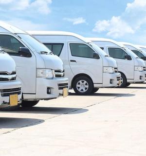 a row of white vans parked in a parking lot