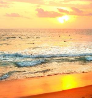 a man walking on the beach with a surfboard