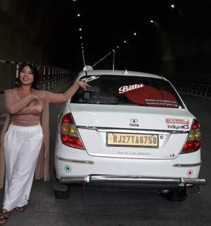 一名女子站在一辆白色汽车旁边