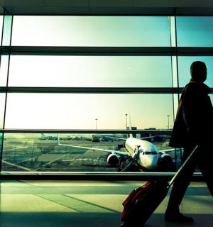 一个人走过机场看着飞机