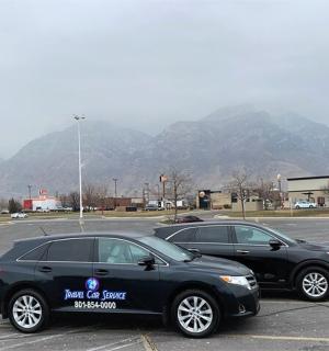 两辆汽车停在停车场，背景是群山