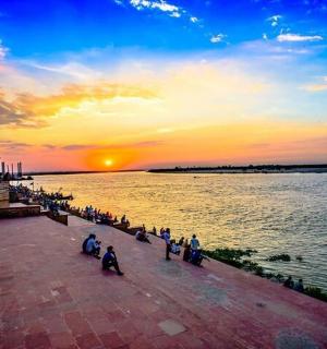 一群人坐在水边的人行道上