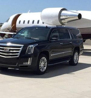 a black truck is parked next to an airplane