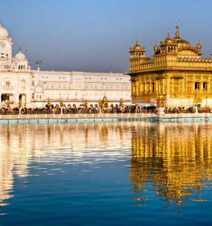 a large building with a reflection in the water
