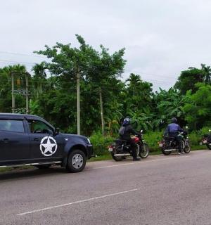 a group of motorcyclists are parked on the side of a road
