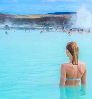 一位女士坐在蓝色泻湖的水中