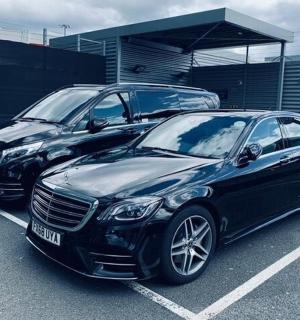 two black cars parked in a parking lot