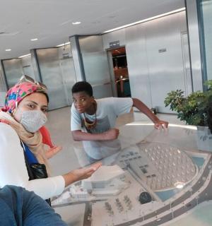 skupina lidí stojící kolem skleněného stolu