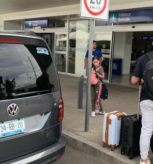 一名背着背包的男子站在一辆载有行李的货车旁