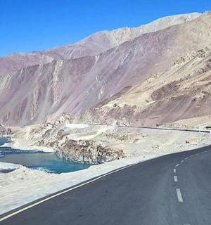 a road in the middle of a mountain with a river