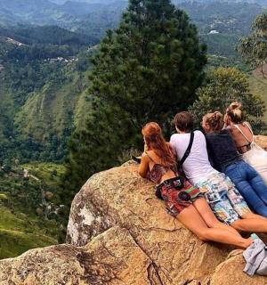 a group of women sitting on top of a rock