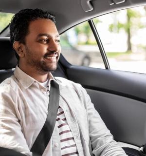 egy nyakkendőt viselő férfi ül egy autóban