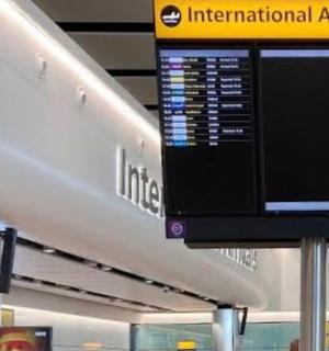 an airport terminal with a large monitor in an airport