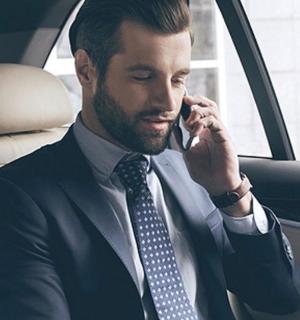 a man sitting in a car talking on a cell phone