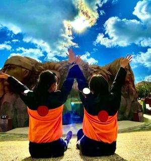 two girls are sitting in front of an amusement park