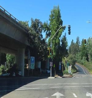 an intersection with an overpass with a road and traffic lights