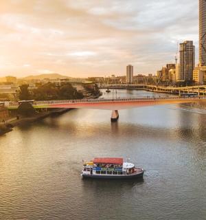 a boat on a river in a city with a bridge