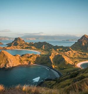 a view of a beach with mountains and water