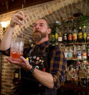 a man is holding a glass in a bar