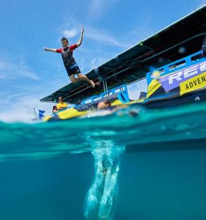 一名男子站在水中的船上