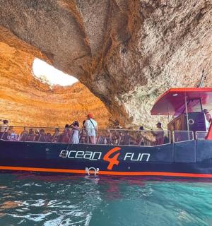 a boat in the water in front of a cave