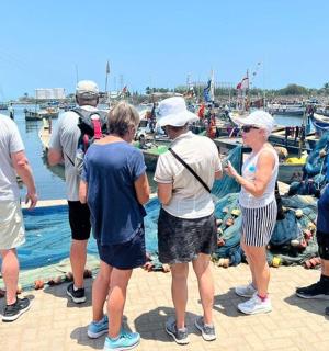 一群人站在码头上看着一艘船