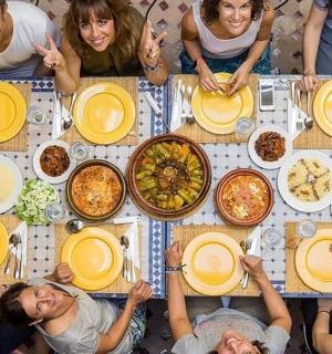 a group of people sitting around a table with food