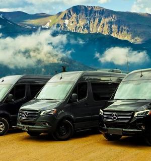 bir dağın önüne park edilmiş dört minibüsten oluşan bir grup