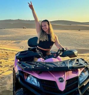 一名女子在沙漠中骑着四轮摩托车
