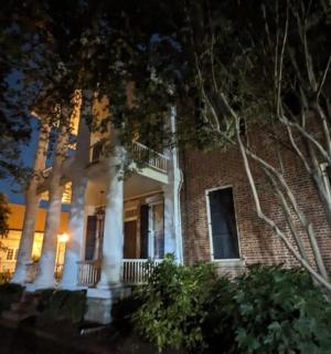 ein großes Backsteingebäude mit weißen Säulen in der Nacht